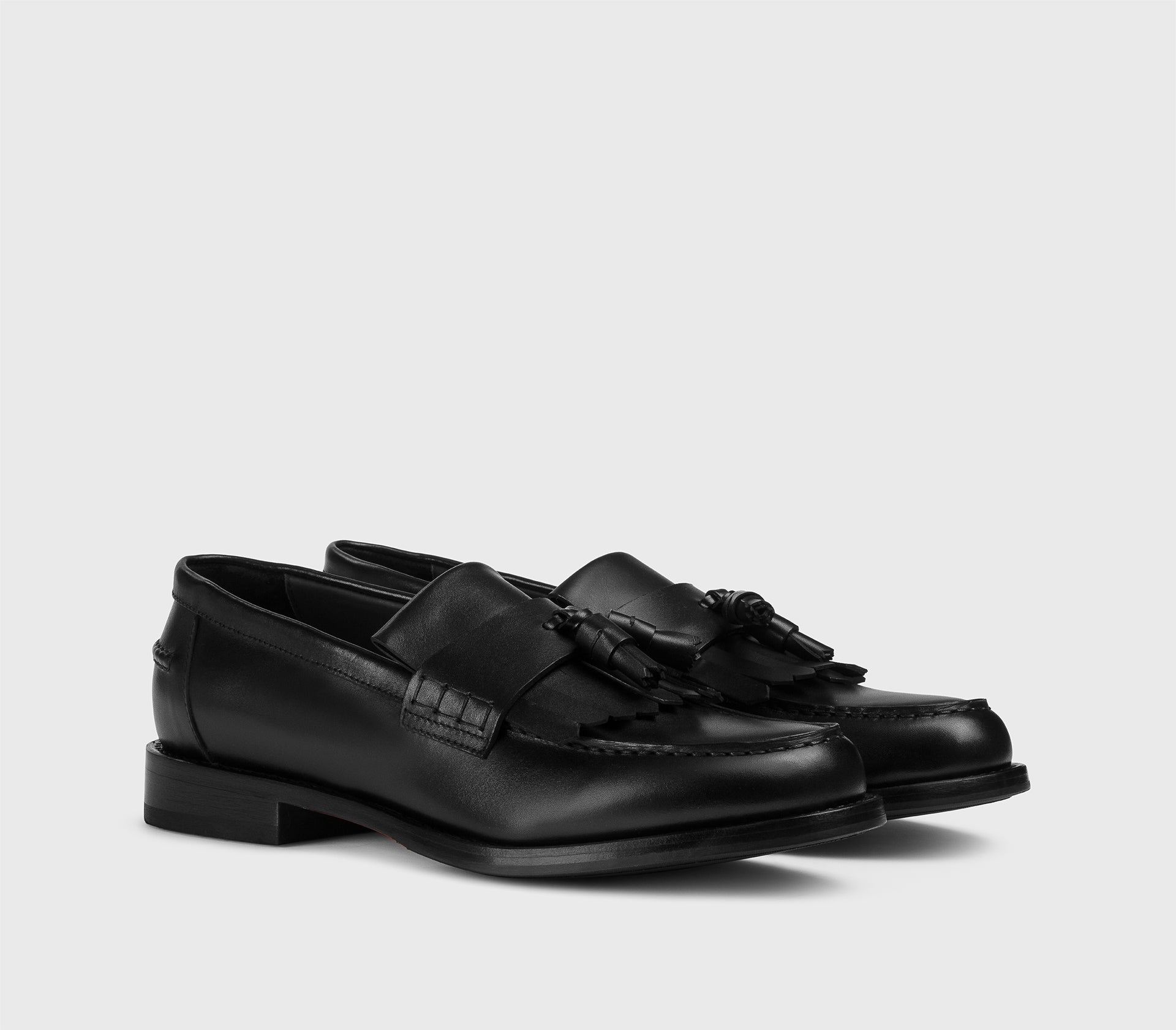 Black leather loafer with tassels and fringe